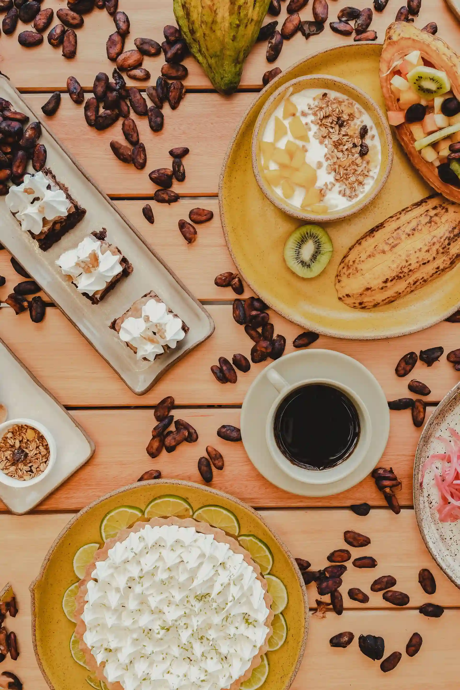 Café da manhã do Nibs visto de cima: amêndoas de cacau torradas, torta de limão e um fruto de cacau usado como cumbuca
