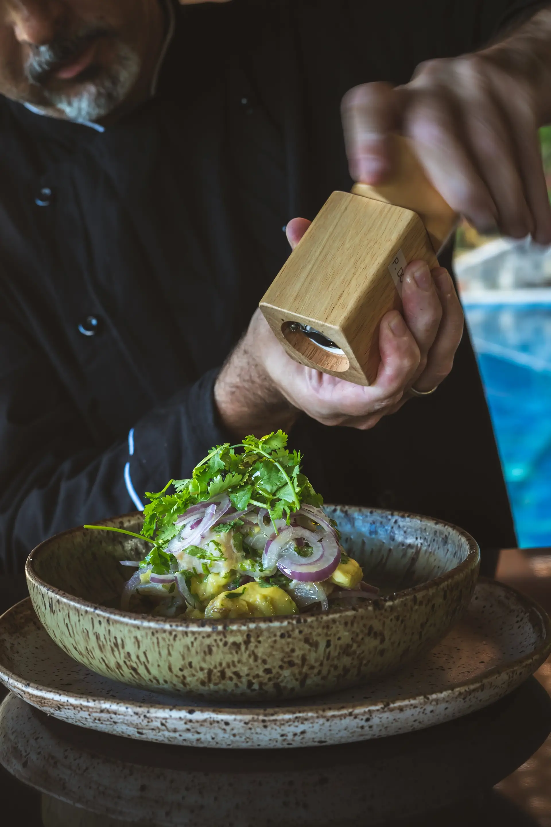 The Nibs chef finishing a dish with fresh chilli