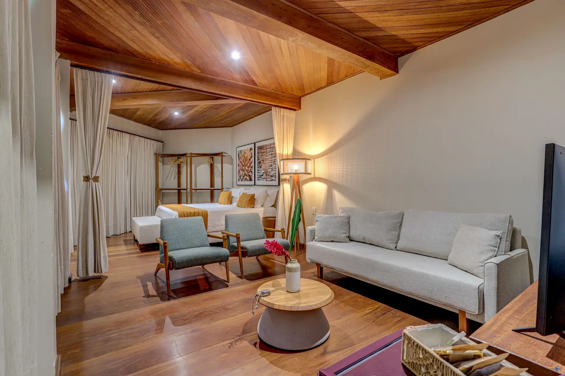 A sala da Grand Cru, com o sofá e as poltronas, e a cama no fundo