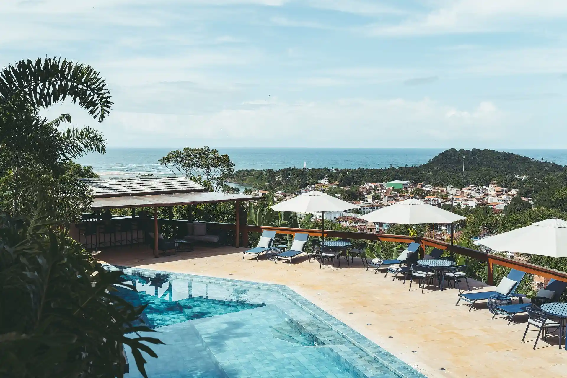 The Chocolate Hotel pool in the foreground and the open sea behind, in morning light