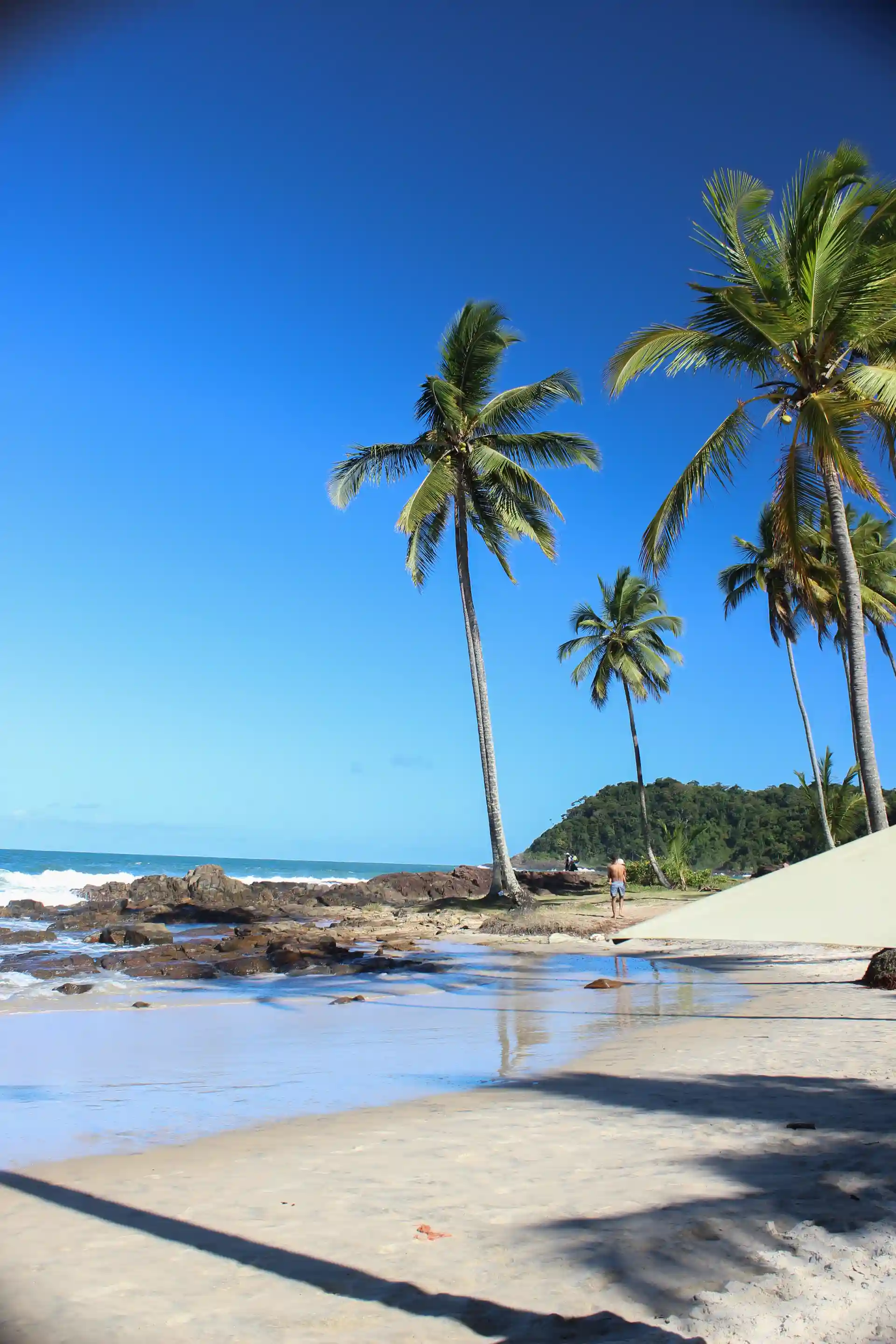 Resende beach in Itacaré, small, with the green slope and rocks at the water’s edge