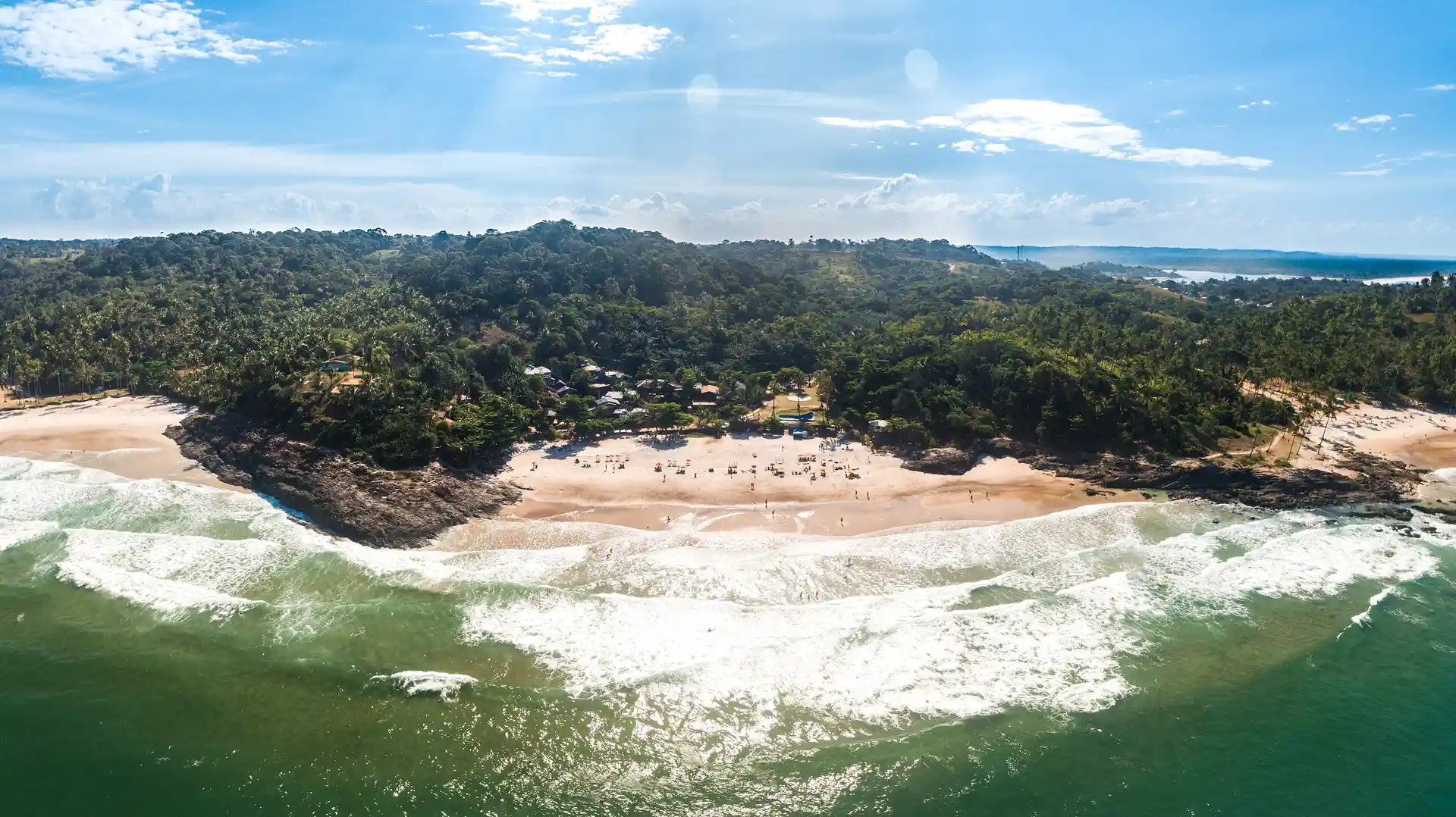 A Praia da Tiririca vista do alto, com a arrebentação, a areia e a mata fechando a enseada