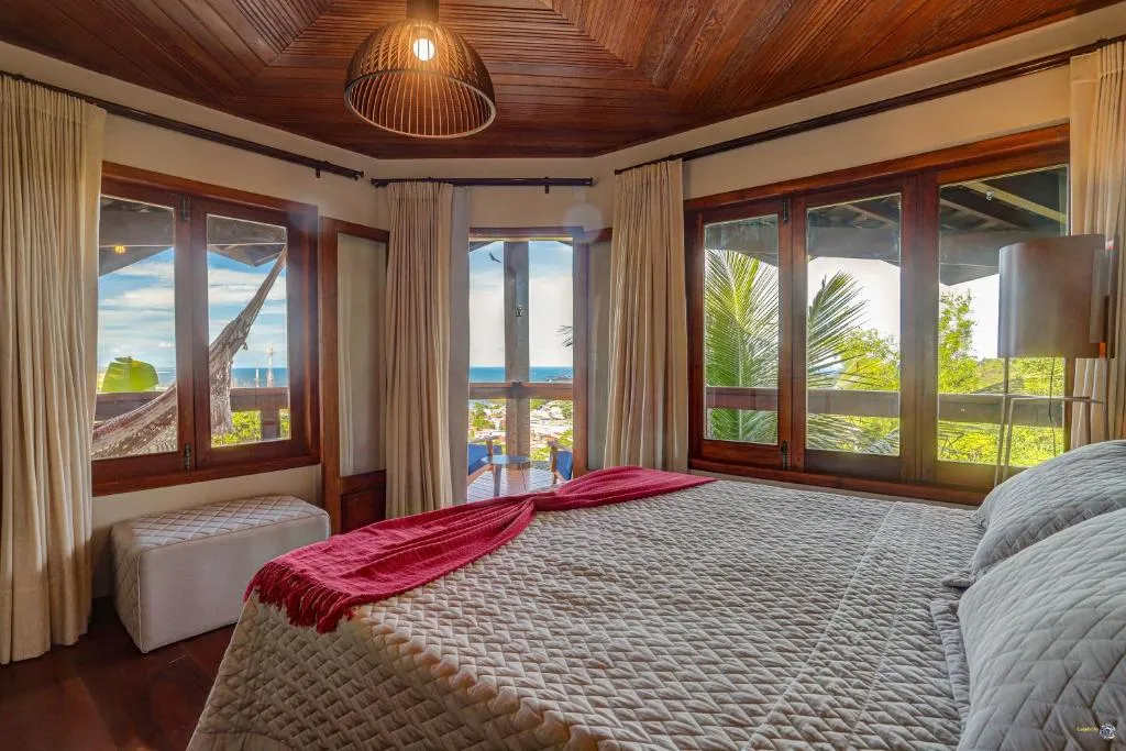 Uma suíte Torra: a cama queen size e o mar aberto nas janelas de canto
