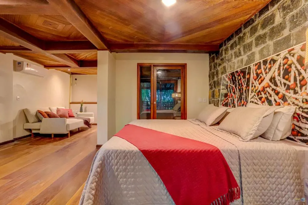 The stone wall of a Tulha suite, with the cocoa mural beside the bed